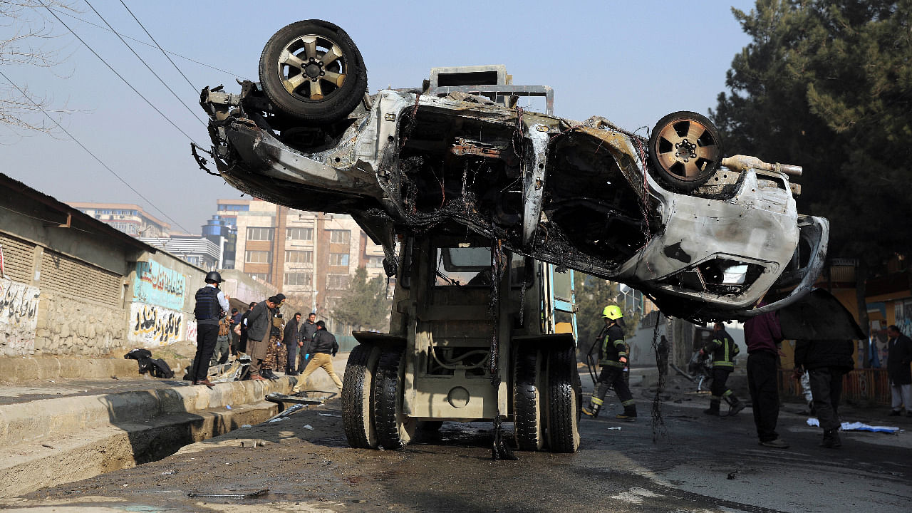 Afghan security personnel remove a damaged vehicle after a bomb attack in Kabul, Afghanistan. Credit: AP Photo