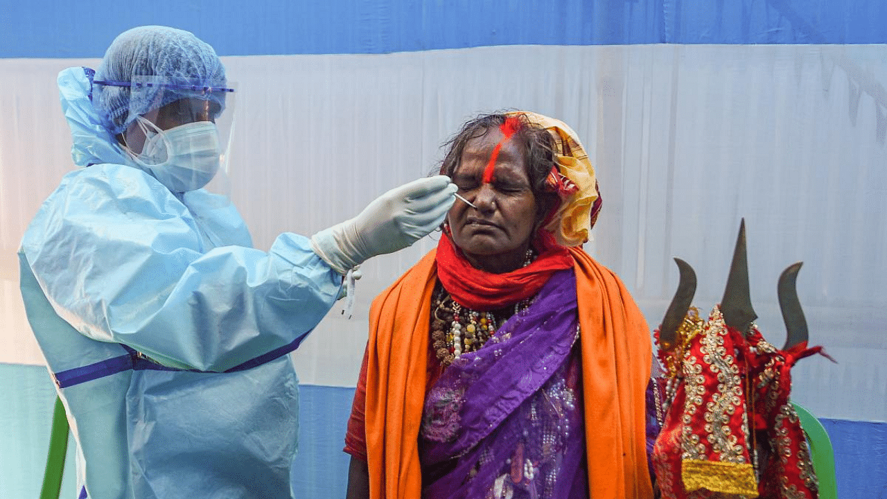  A health worker collects a nasal sample from a hermit for Covid-19 testing, at Babughat transit camp in Kolkata. Credit: PTI Photo
