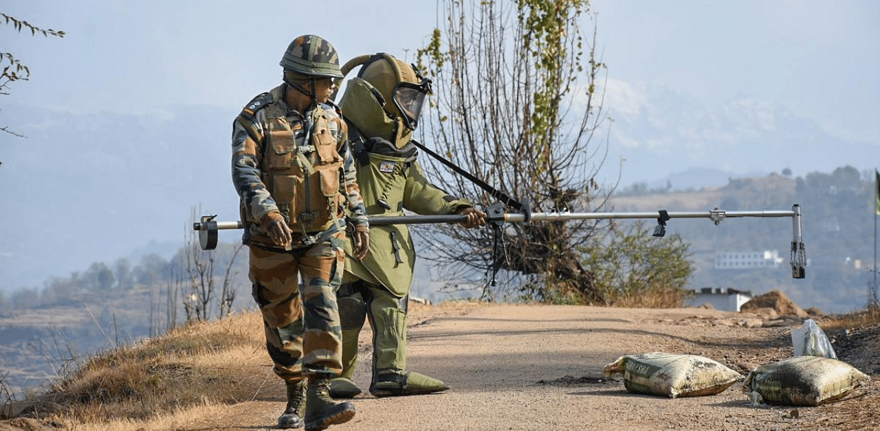 Bomb Disposal Squad members of the Indian Army defuse a 2.4kg Improvised Explosive Device (IED) along the Gohlad Mendhar road near LoC, in Mendhar area of Poonch district. Credit: PTI Photo