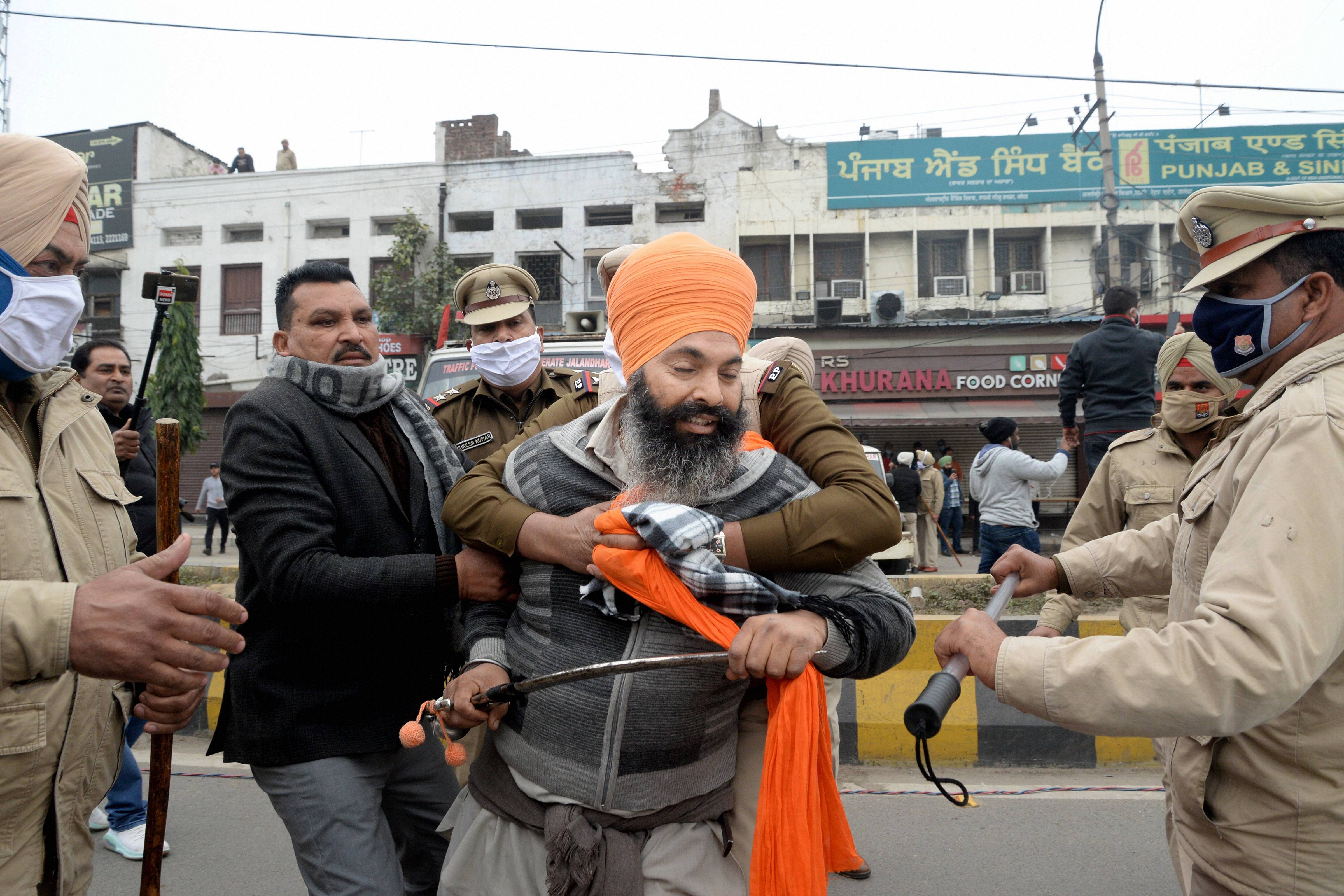 Police stop farmers as they try to stop the ongoing Punjab BJP President Ashwani Sharma's function during their protest, in Jalandhar, Sunday, Jan. 10, 2021. Credit: PTI Photo