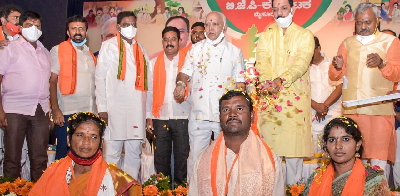 Chief Minister B S Yediyurappa and State BJP president Nalin Kumar Kateel symbolically honour three Grama Panchayat members, during the Jana Sevak Samavesha, in Mysuru, on Monday. Credit: DH Photo