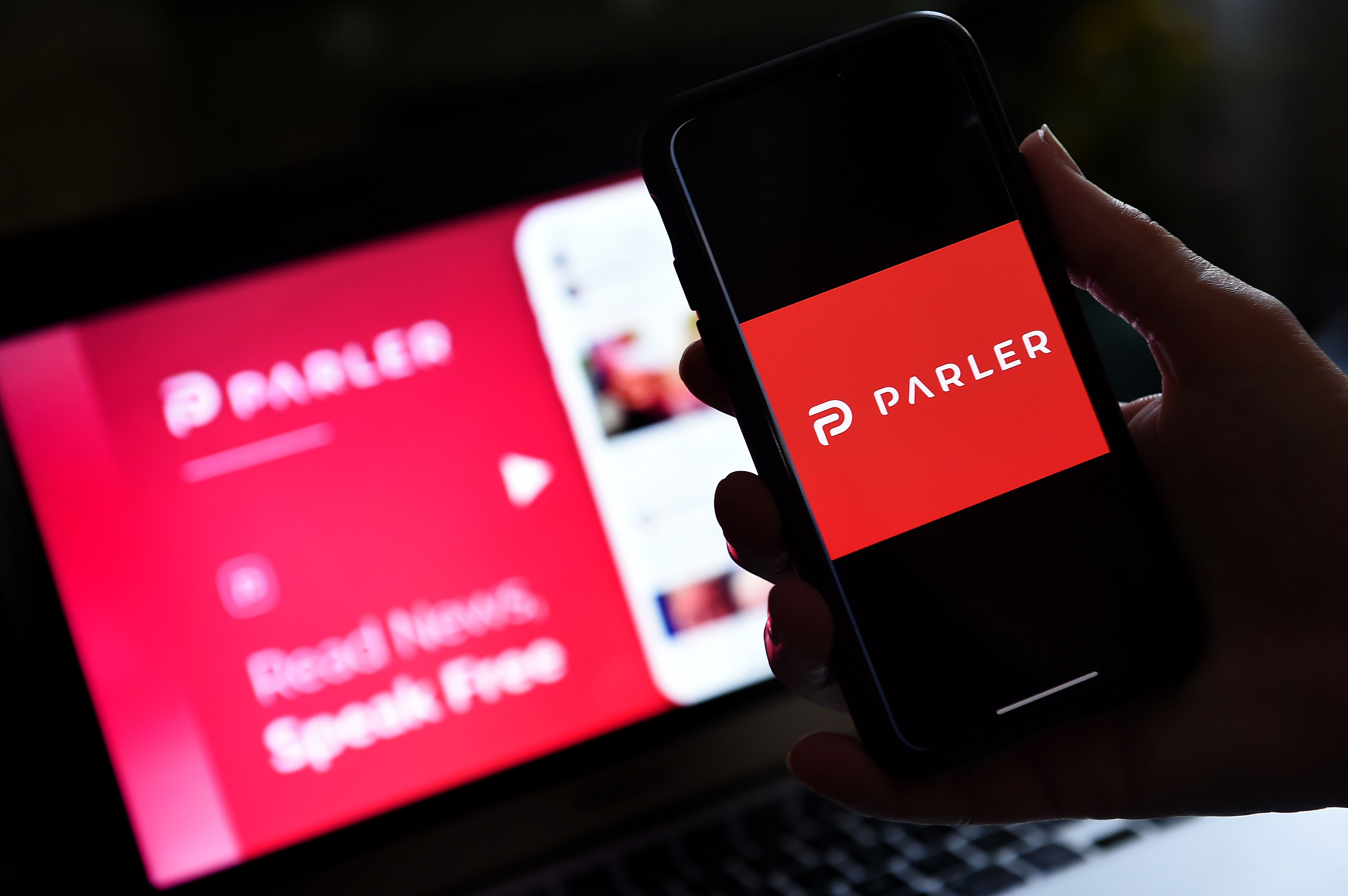 Media application logo from Parler displayed on a smartphone with its website in the background. Credit: AFP Photo