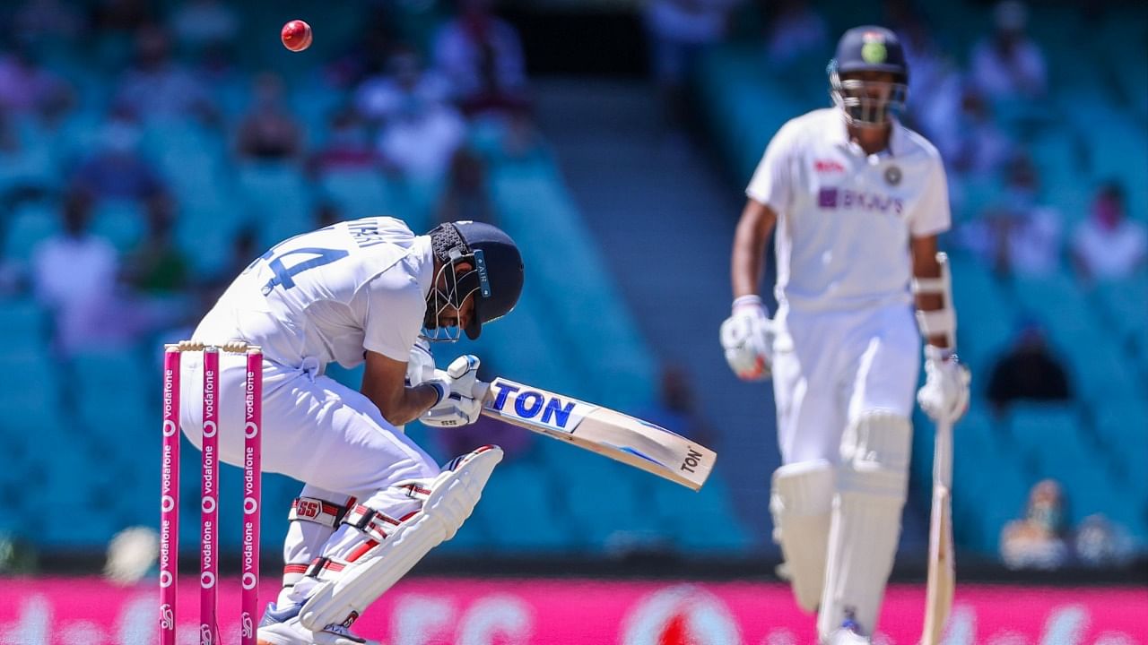 India's Hanuma Vihari (L) avoids a bounder as his teammate Ravichandran Ashwin watches during the fifth day of the third cricket Test match between Australia and India. Credit: AFP Photo