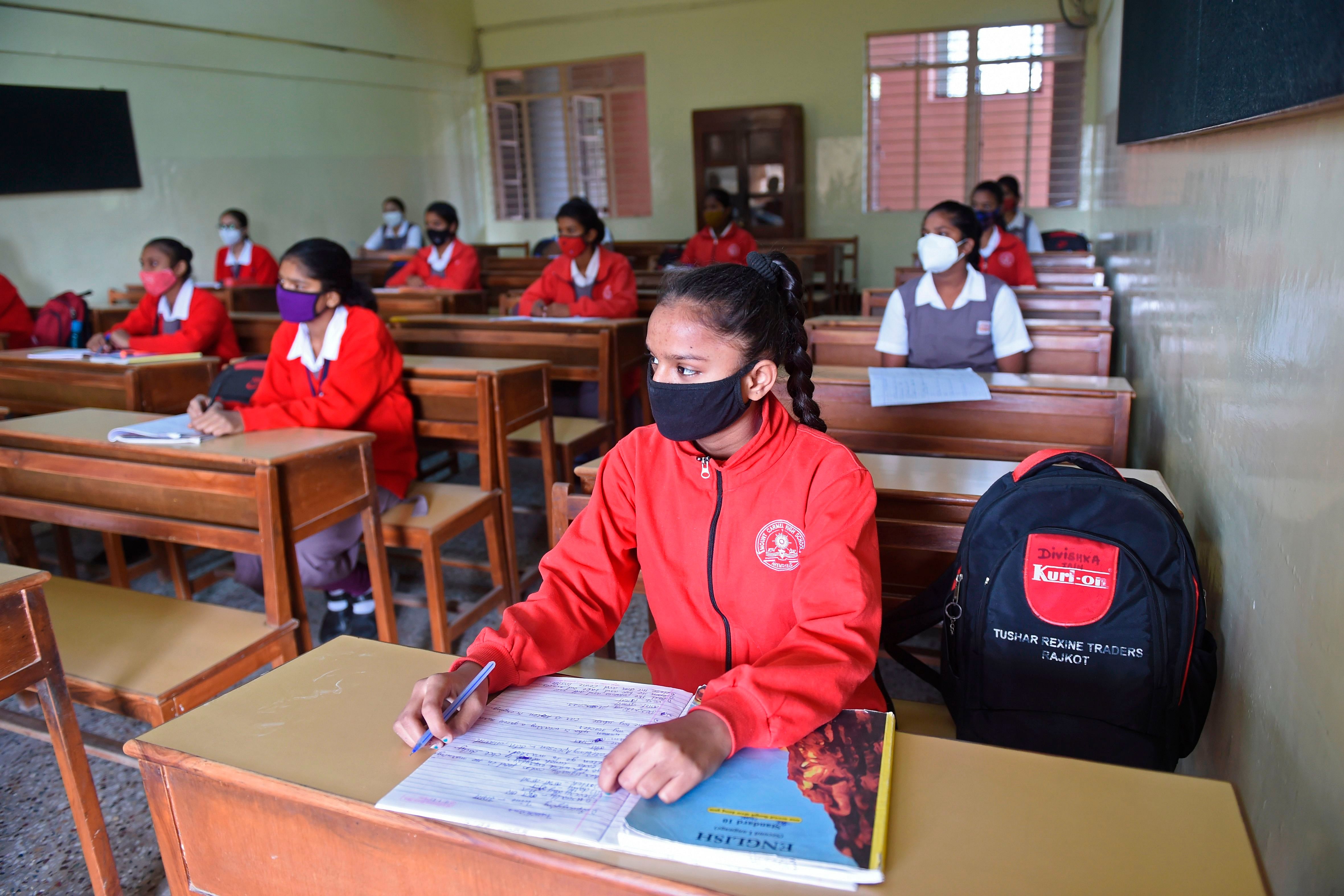 Students wearing facemasks attend their class after the schools for 10th and 12th classes were reopened nearly nine months after the spread of the Covid-19 coronavirus in Ahmedabad on January 11, 2021. credit: AFP Photo