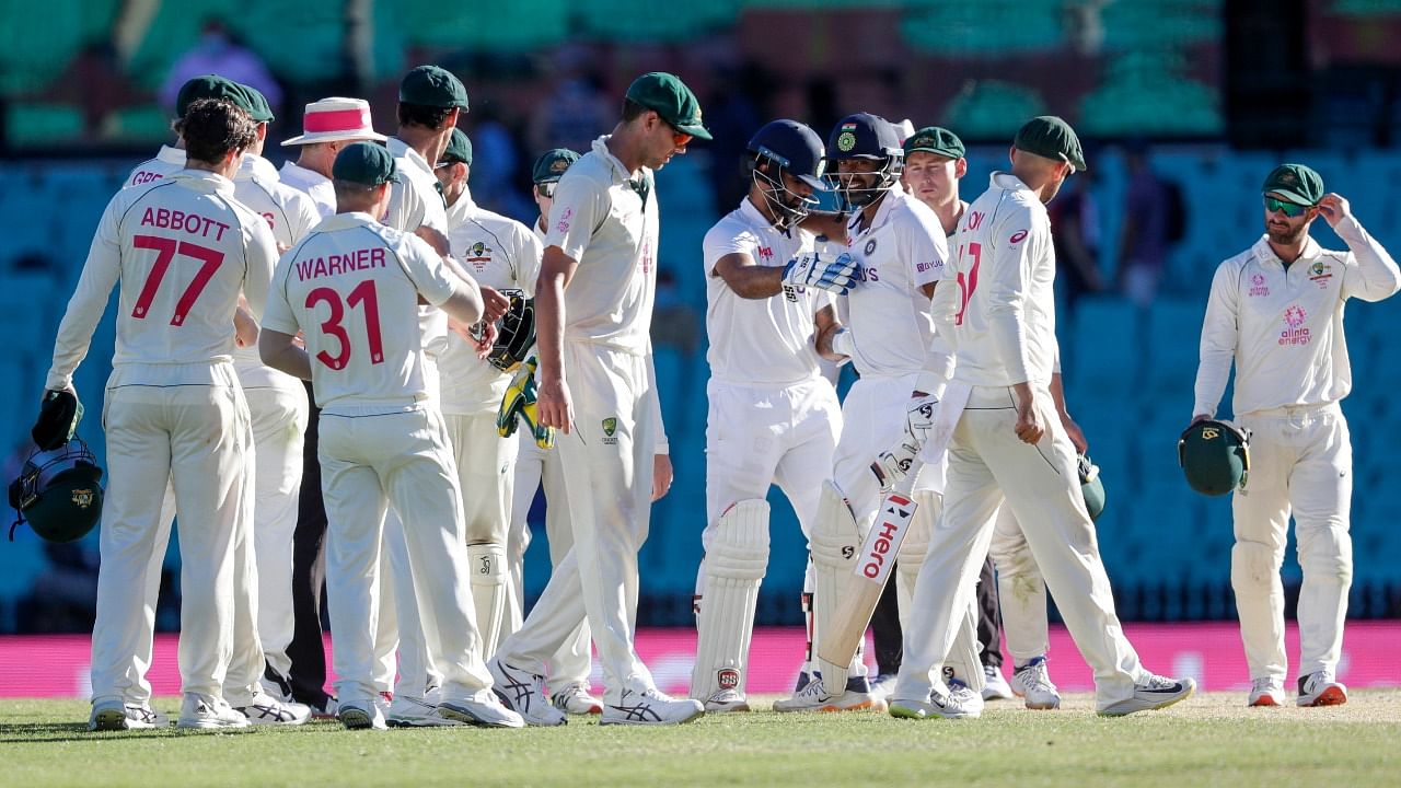 Indian batsman Ravichandran Ashwin and Hanuma Vihari, blue helmets, react as Australian players look on at the end of play on the final day of the third cricket test between India and Australia. Credit: AP/PTI Photo