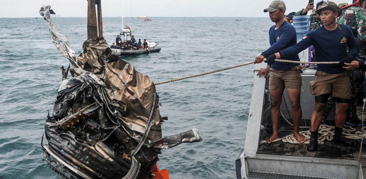Indonesian Navy members pull up a piece of debris during a search for the remains from Sriwijaya Air flight SJ 182, which crashed into the sea off the Jakarta coast, Indonesia. Credit: Reuters Photo