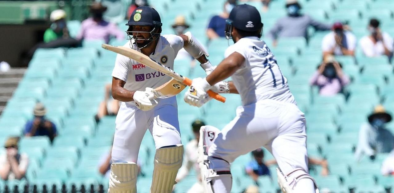 Indian batsmen Rishabh Pant (R) and Cheteshwar Pujara run between the wickets during day five of the third cricket Test match between Australia and India at the Sydney Cricket Ground (SCG) on January 11, 2021. Credit: AFP Photo