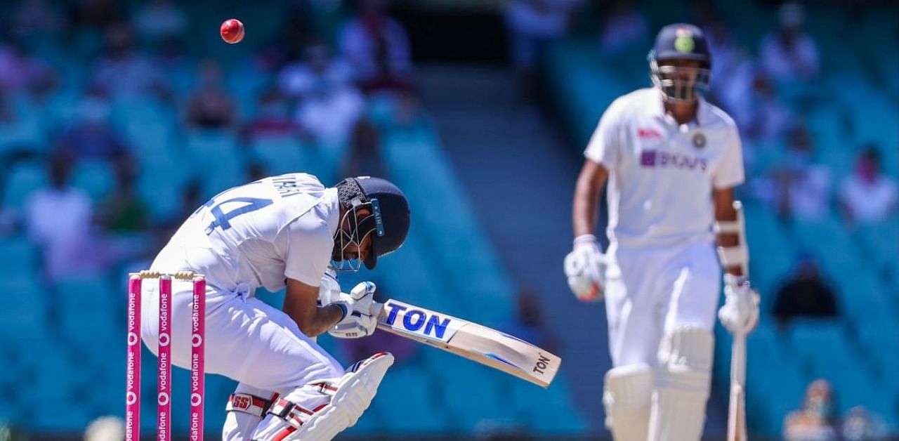 India's Hanuma Vihari (L) avoids a bounder as his teammate Ravichandran Ashwin watches during the fifth day of the third cricket Test match between Australia and India at the Sydney Cricket Ground (SCG) in Sydney on January 11, 2021. Credit: AFP Photo