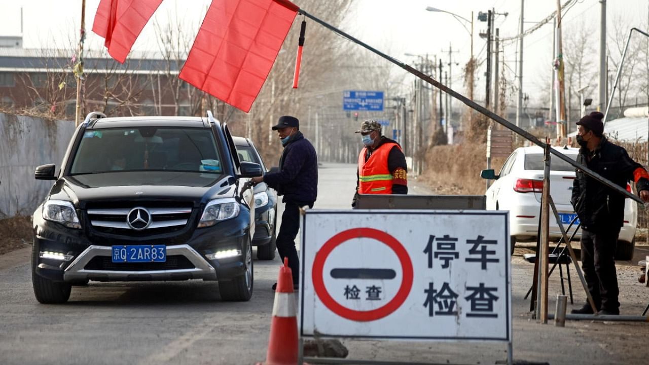 Volunteers stop a car at a checkpoint on a road leading into their village, following a Covid-19 outbreak, on the outskirts of Beijing near the provincial border with Hebei province. Credit: Reuters.