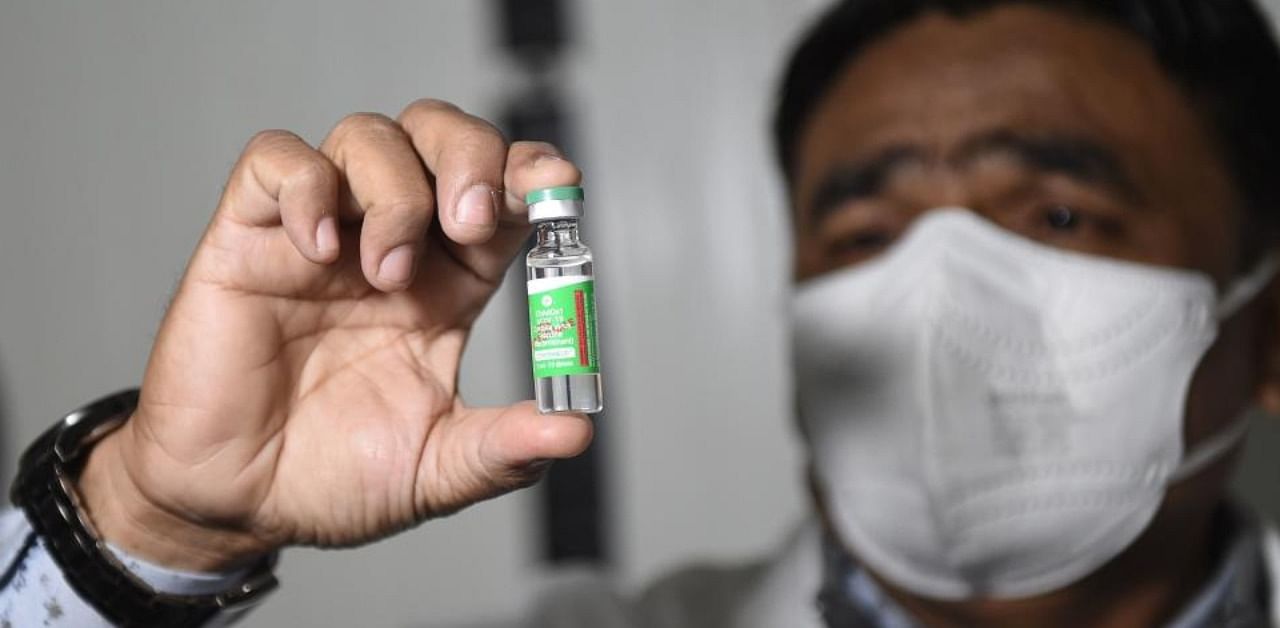 Regional Pharmacist, Idrish Mansuri holds a vial containing Covishield vaccine at the Regional Vaccine Store in Ahmedabad on January 12, 2021. Credit: AFP Photo