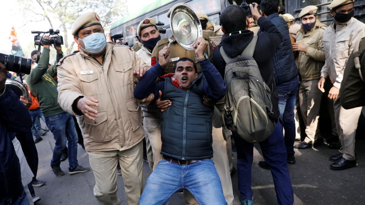 Police officers detain an activist of the youth wing of India's main opposition Congress party during a protest against new farm laws in New Delhi. Credit: Reuters.