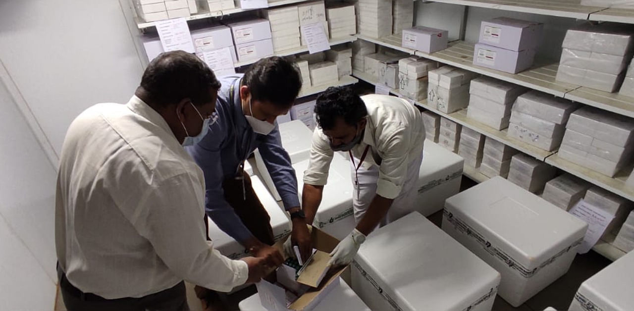 Health Department personnel check Covid-19 vaccines on its arrival at Vaccine Depot in Belagavi on Wednesday. Credit: DH Photo/ Eknath Agasimani