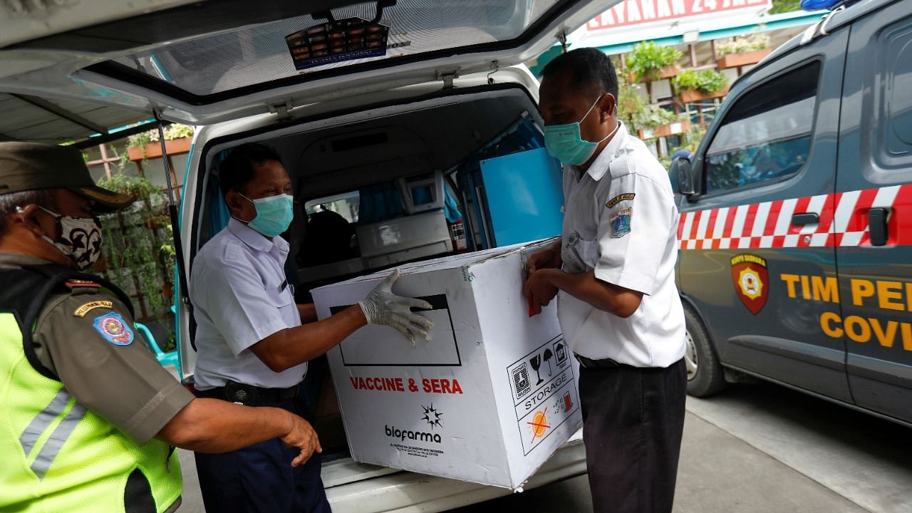 Officers carry off a box of the coronavirus vaccine after it arrived at a district health facility, as Indonesia starts mass vaccinations, in Jakarta, Indonesia on January 13, 2021. Credit: Reuters Photo/Willy Kurniwan