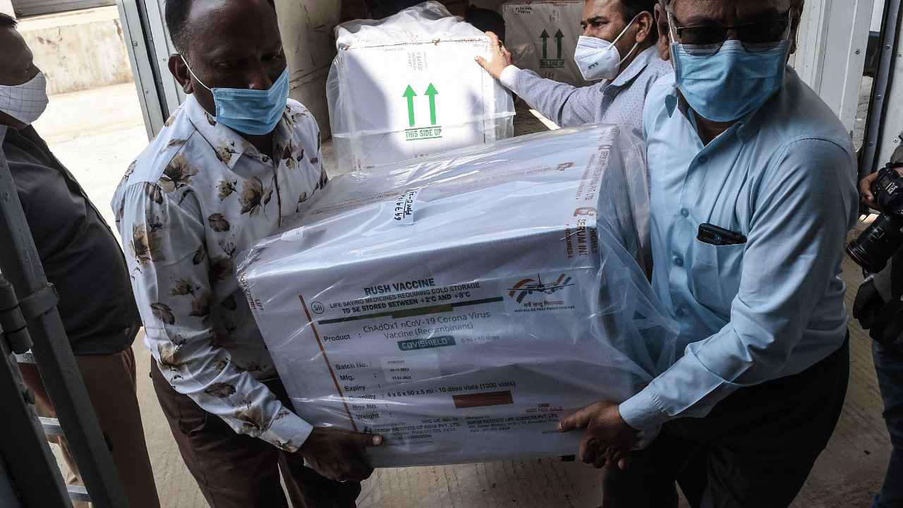 Officials unload boxes containing Covishield vaccine. Credit: PTI Photo