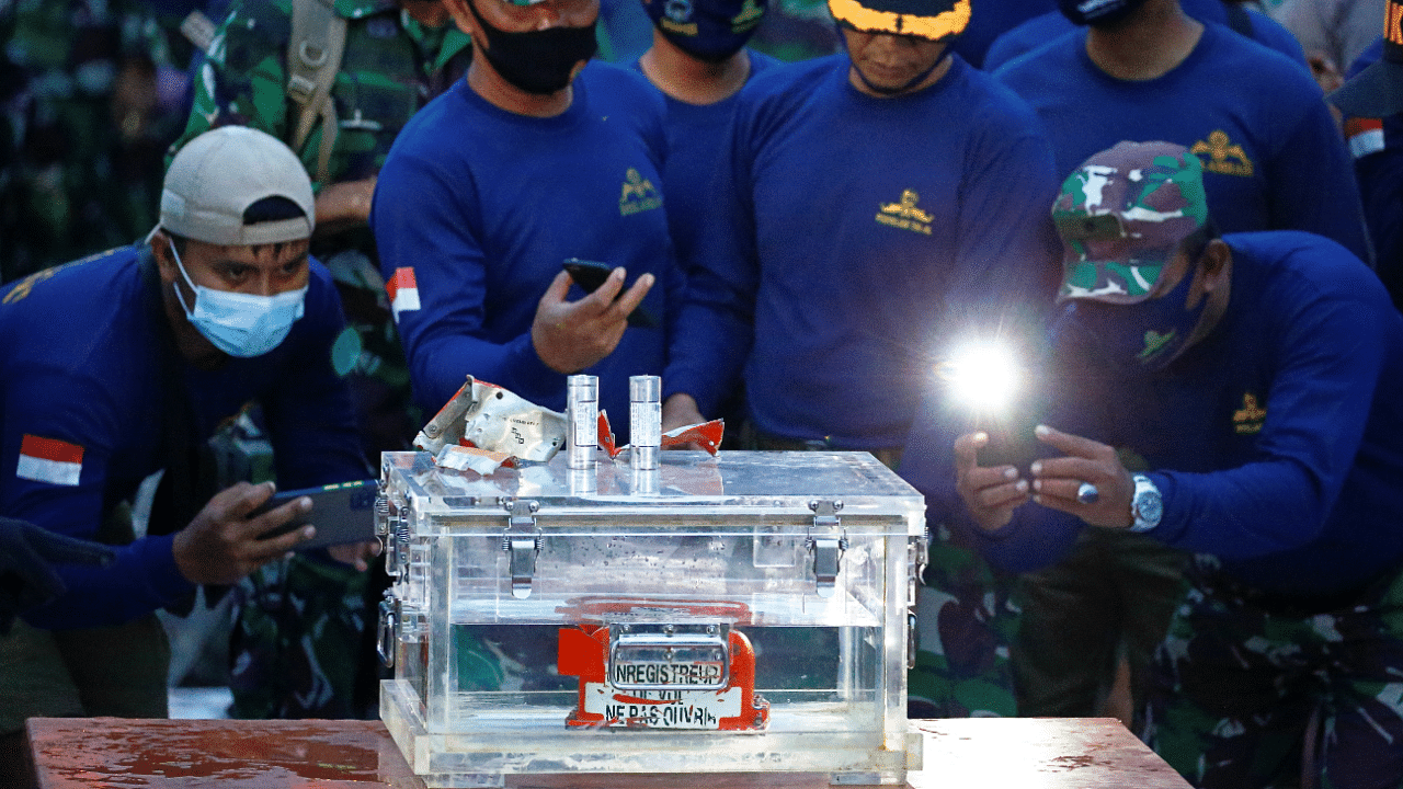 Indonesia navy members take a picture of a part of the retrieved black box of Sriwijaya Air flight SJ 182, which crashed into the sea at the weekend off the Jakarta coast, in Jakarta, Indonesia. Credit: Reuters Photo