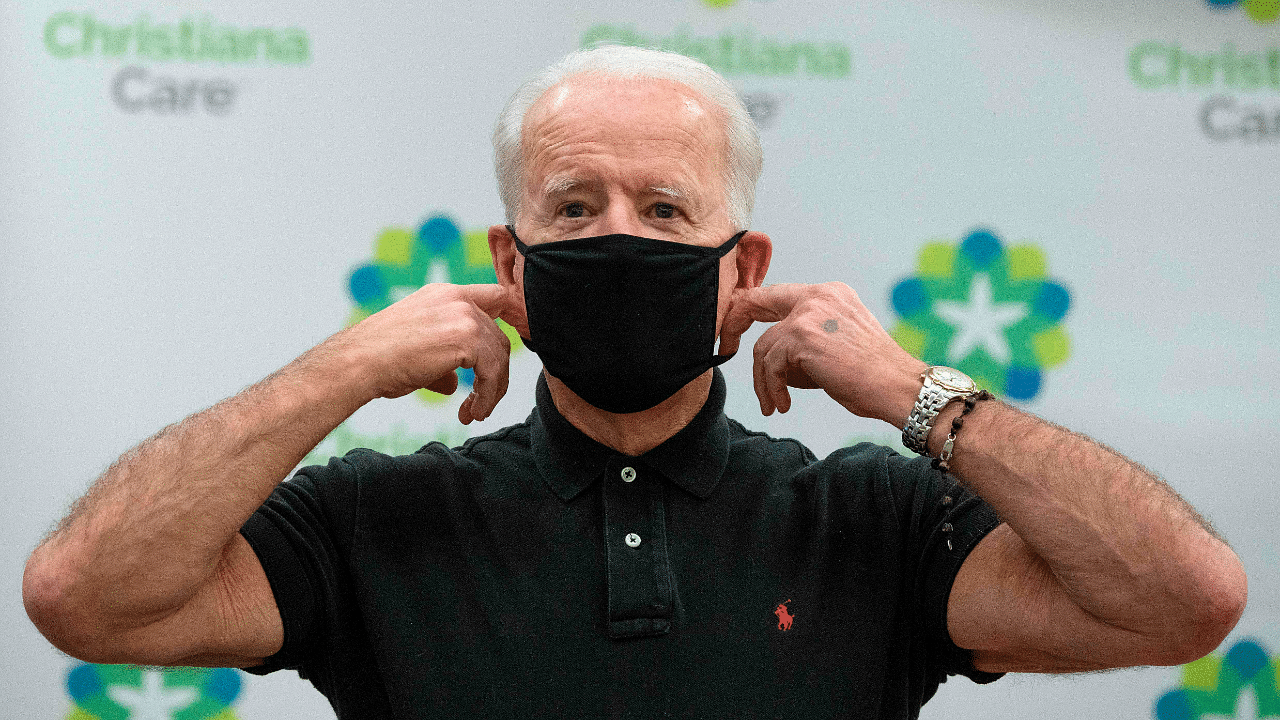 US President-elect Joe Biden adjusts his facemask. Credit: AFP File Photo