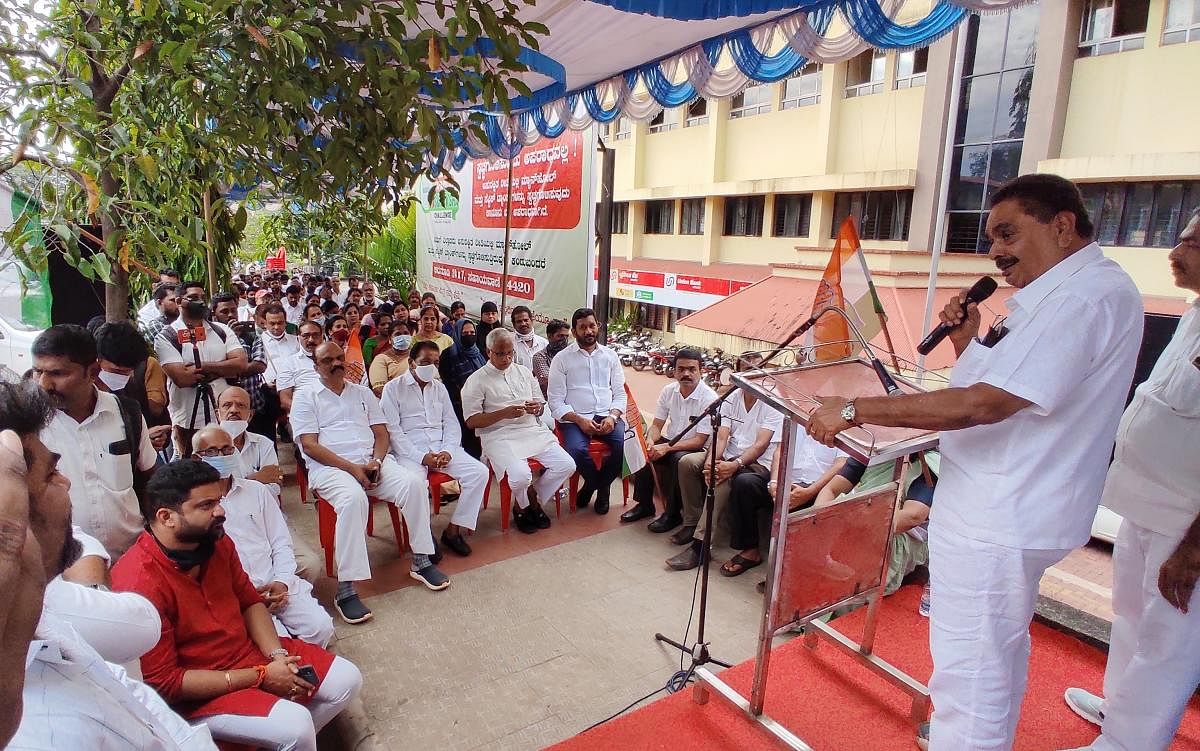 Former minister B Ramanath Rai addresses protesters in front of Mangaluru City Corporation building in Lalbagh in Mangaluru on Tuesday. DH Photo