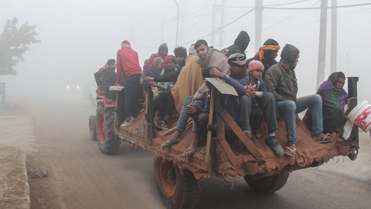 People travel on a tractor trolly amid low visibility due to dense fog on a cold winter morning, in Gurugram. Credit: PTI File Photo
