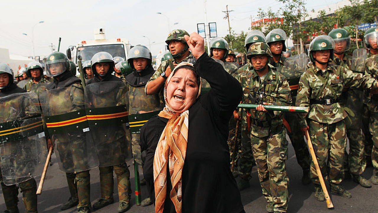 An Uighur woman protests in front of policemen at a street on July 7, 2009 in Urumqi, the capital of Xinjiang Uighur autonomous region, China. Credit: Getty Images