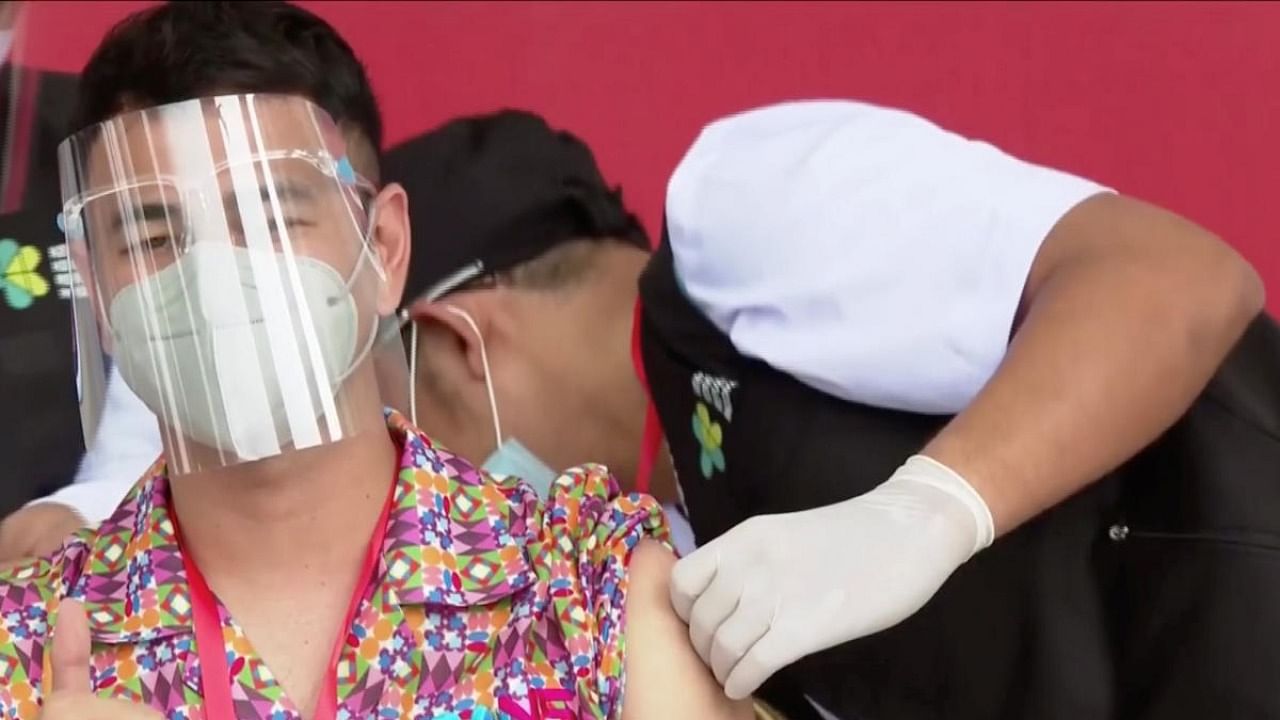 Indonesian influencer Raffi Ahmad gestures while receiving a shot of the coronavirus vaccine at the Merdeka Palace in Jakarta in a screen grab from January 13, 2021 handout video from Indonesian Presidential Palace. Credit: Reuters Photo