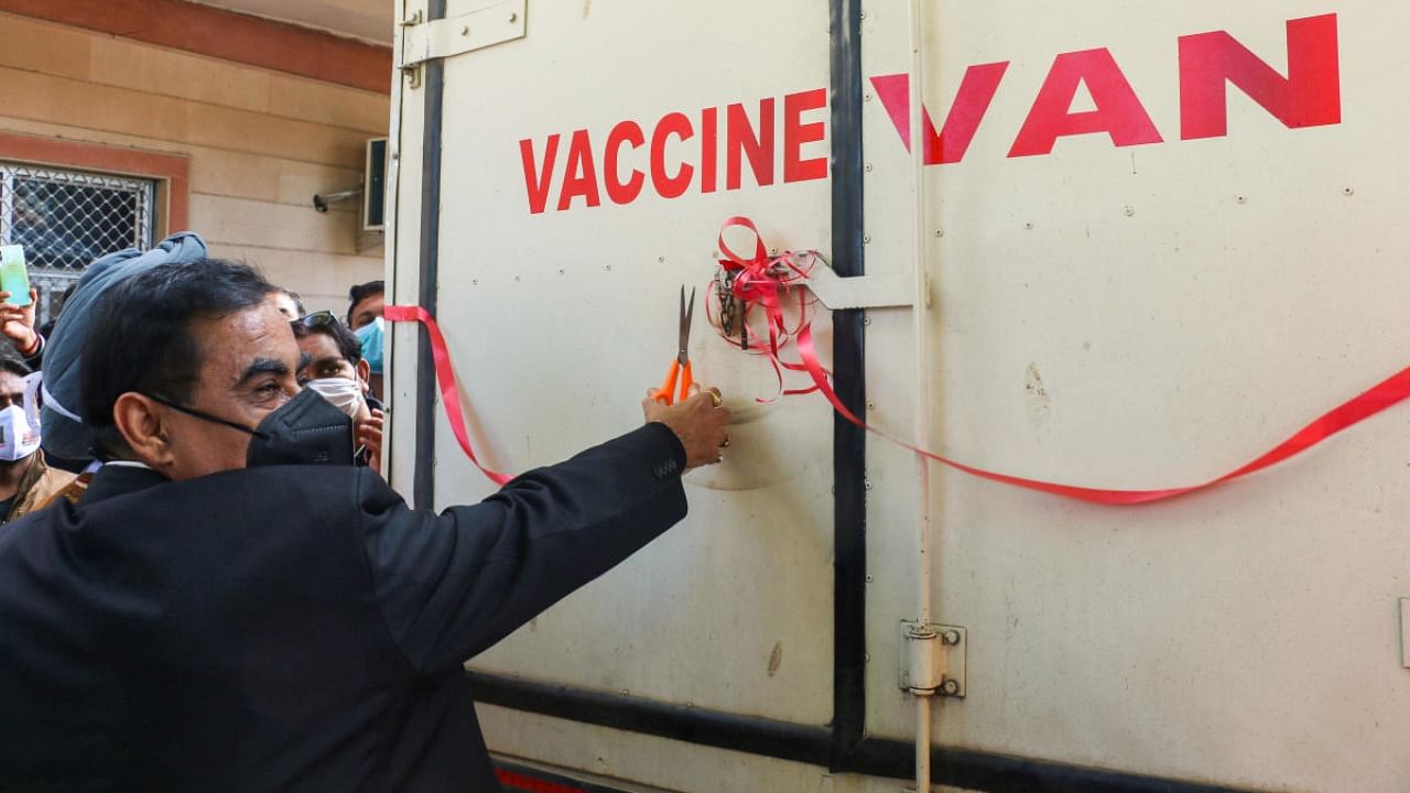 An official cuts the ribbon as the first batch of Covid vaccine arrives at a storage facility in Ajmer. Credit: PTI Photo