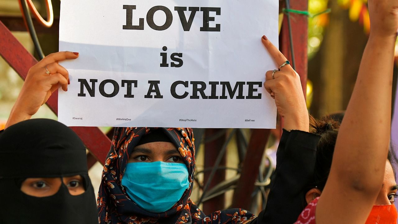 In this file photo taken on December 1, 2020, a civil right activist holds a placard during a demonstration condemning the decision of various Bharatiya Janata Party (BJP) led state governments in the country for the proposed passing of laws against "Love Jihad" in Bangalore. Credit: AFP Photo