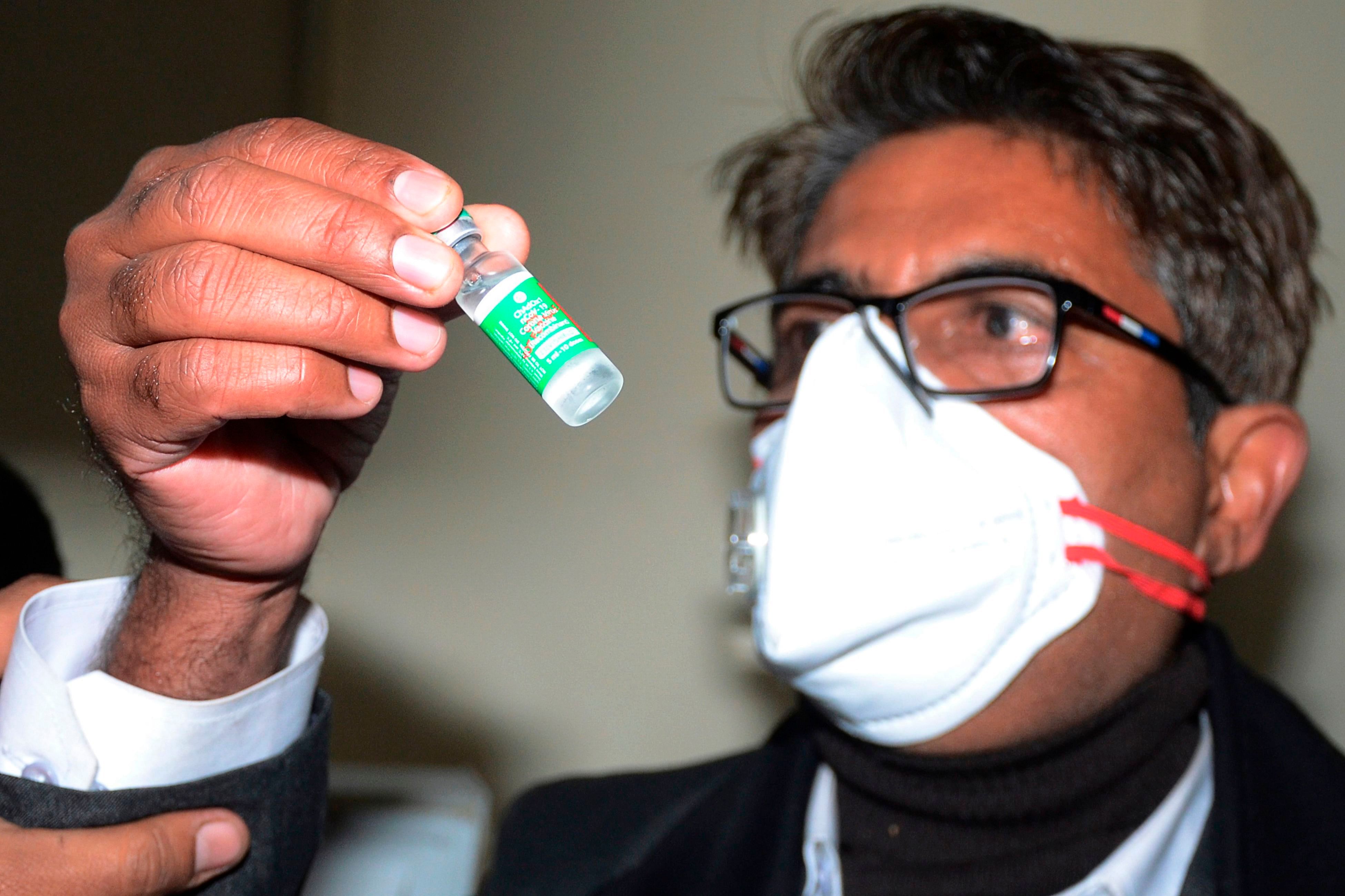 A health department official holds a vial containing Covishield vaccine at the Regional Vaccine store in the Civil Surgeon Office in Amritsar on January 14, 2021. Credit: AFP Photo