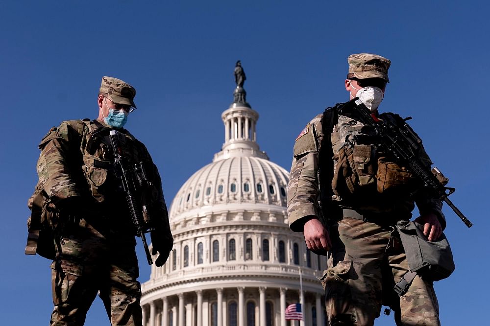 Members of the National Guard walk past the Dome of the Capitol Building on Capitol Hill. Credit: AP Photo