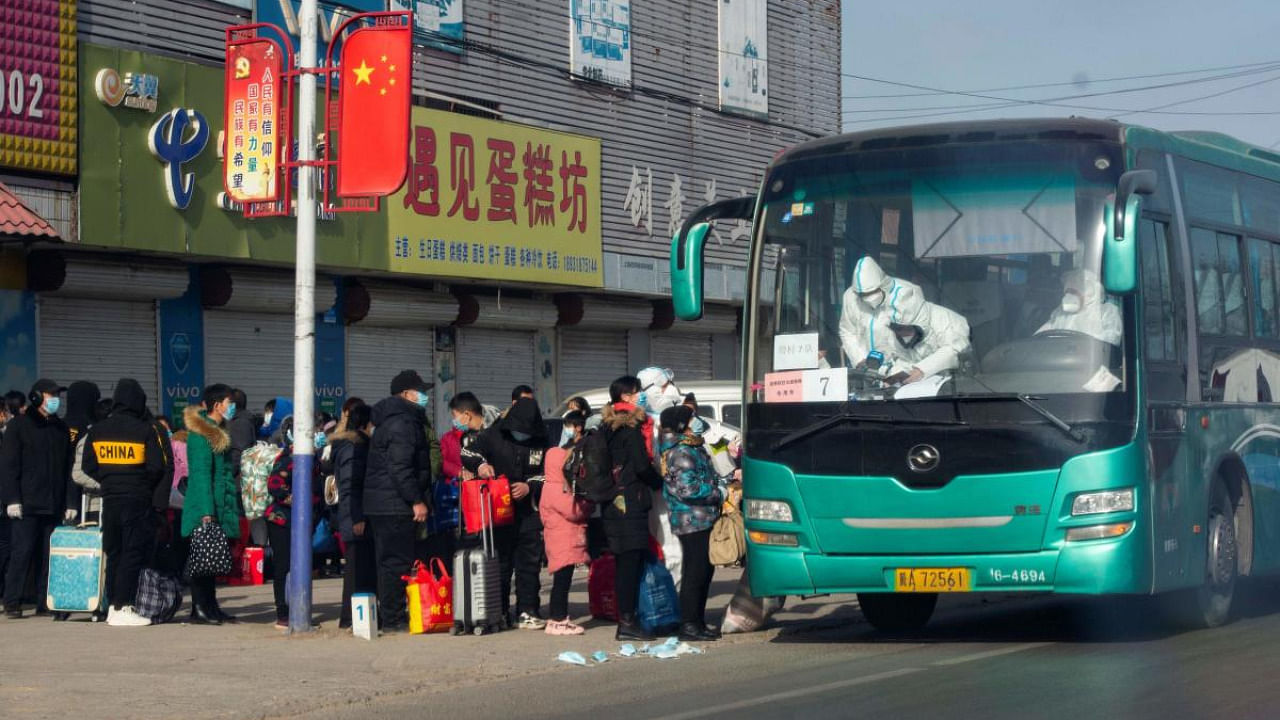 This file photo taken on January 11, 2021 shows residents lining up to get on a bus at Gaocheng district to be taken to centralized quarantine in Shijiazhuang, in northern China's Hebei province, after the district was declared high risk and sealed off, and tens of thousands have already been tested for the virus. Credit: AFP.