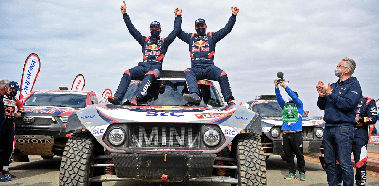 Stephane Peterhansel (R) celebrates with teammates following his victory in the Dakar Rally in Saudi Arabia. Credit: AFP Photo
