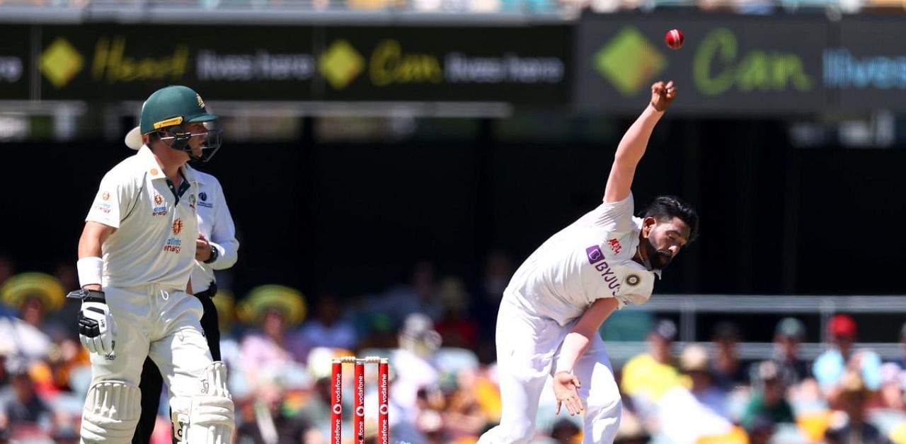 Indian paceman Mohammed Siraj (R) bowls as Australia's batsman Marcus Harris looks on during the day one of the fourth cricket Test match between Australia and India at the Gabba in Brisbane on January 15, 2021. Credit: AFP Photo