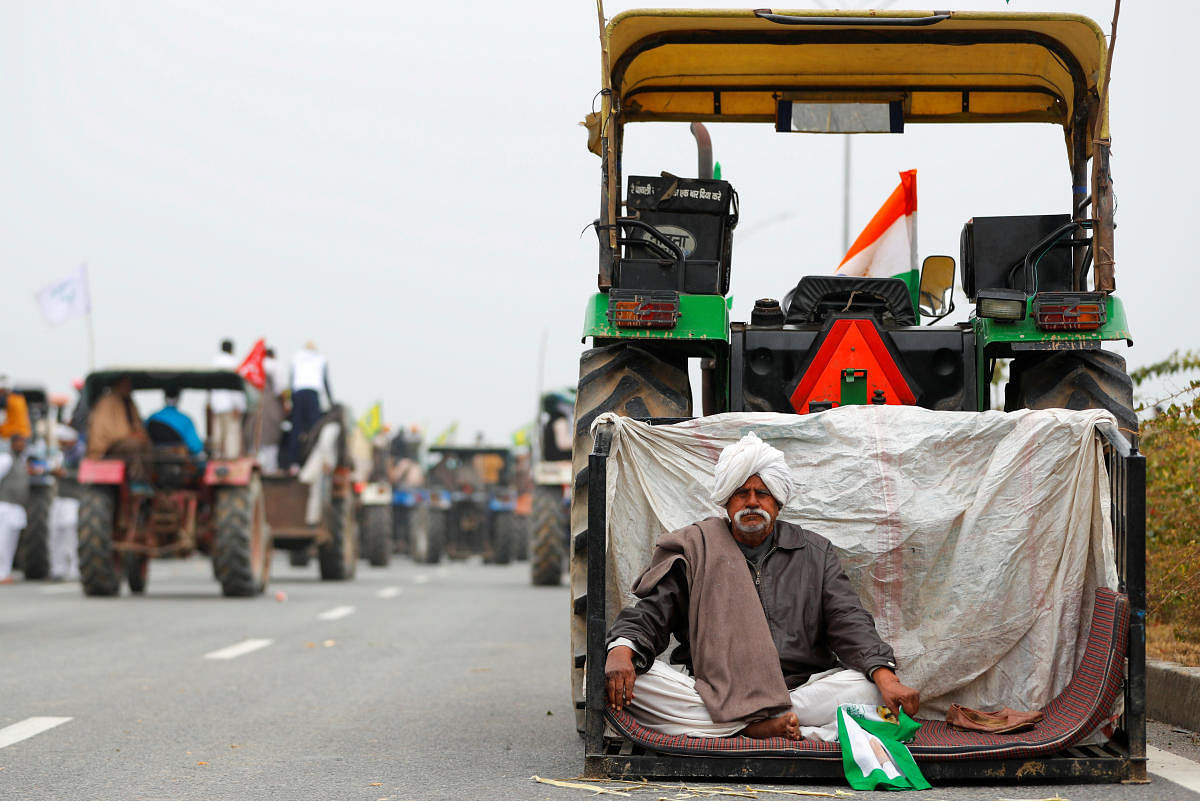 A farmer rests during a tractor rally to protest against the newly passed farm bills, on a highway on the outskirts of New Delhi, India, January 7, 2021. Credit: REUTERS