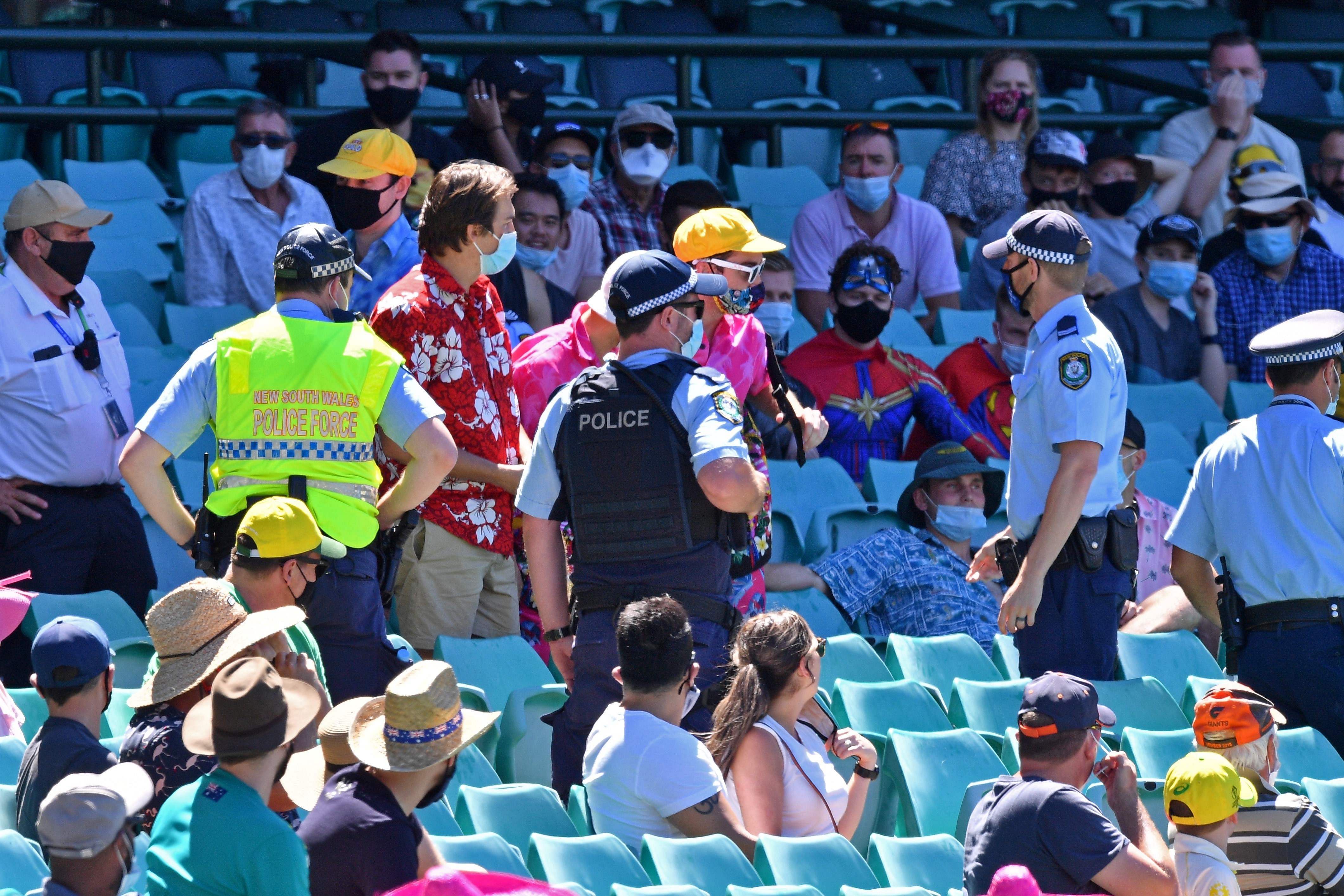 Police speaking to spectators as the game was halted after allegedly some remarks were made by the spectators on the fourth day of the third cricket Test match between Australia and India at the Sydney Cricket Ground (SCG) in Sydney on Jan 10, 2021. - The alleged racist abuse of Indian players by fans at the third Test in Sydney on January 10, 2021 is just the latest in a litany of similar incidents to mar sport in Australia, with authorities struggling to stamp out the problem. Credit: AFP