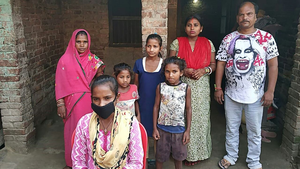 Jyoti Kumari Paswan (C-bottom) and her family stand in front of their house in Siruhully village at Darbhanga district, on May 23, 2020. Credit: AFP Photo