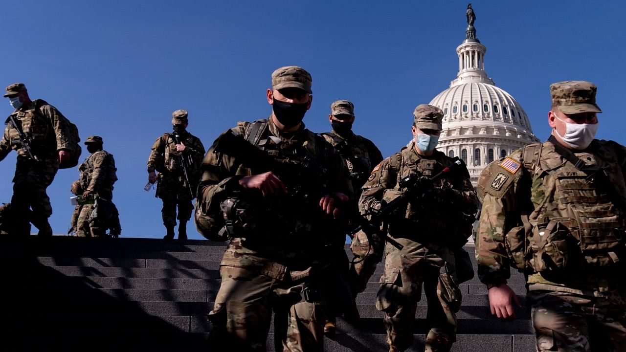 Members of the National Guard walk past the dome of the Capitol Building on Capitol Hill in Washington. Credit: AP/PTI Photo