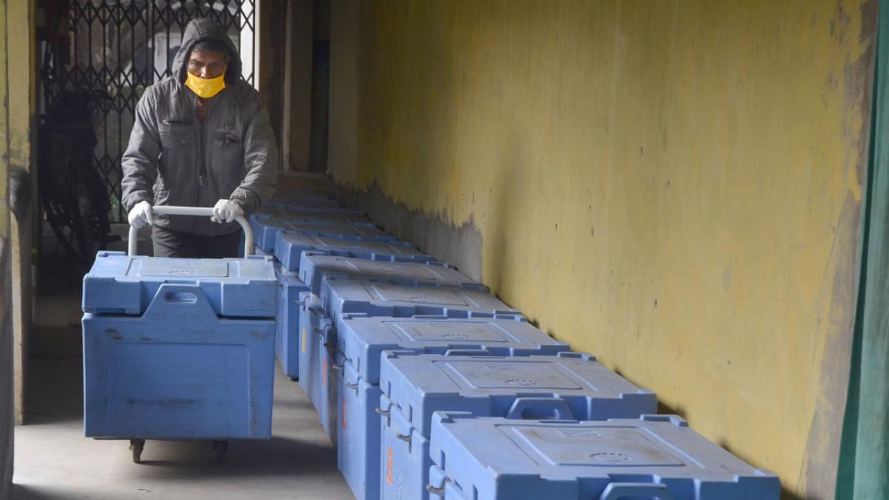 A worker arranges boxes containing Covishield vaccine doses for their dispatch across the Sonitpur district, in Tezpur. Credit: PTI.