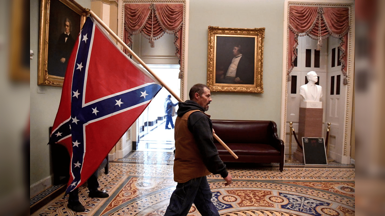 A supporter of President Donald Trump carries a Confederate battle flag on the second floor of the U.S. Capitol near the entrance to the Senate after breaching security defenses, in Washington, U.S., January 6, 2021. Credit: Reuters File Photo