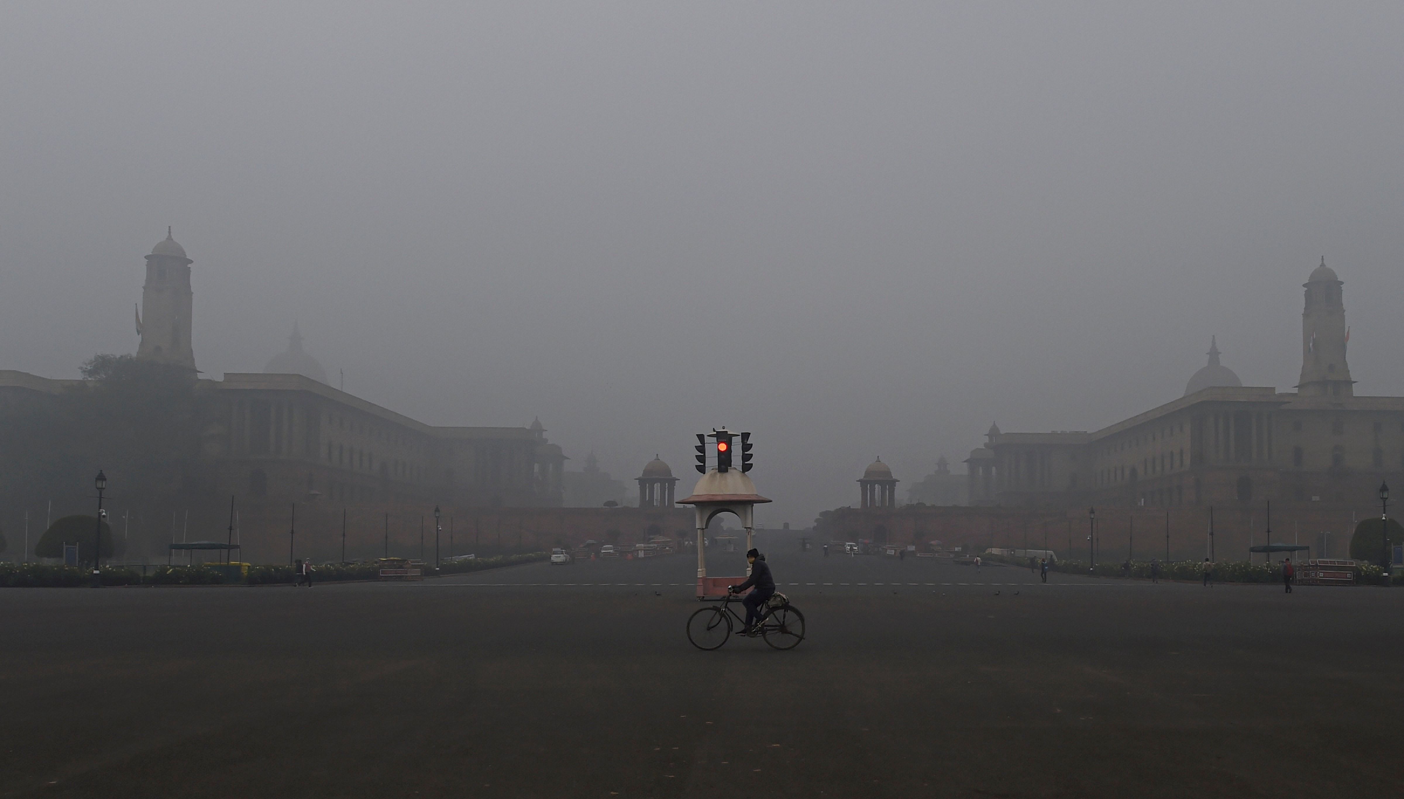 A man rides cycle near the Vijay Chowk, amid a cold and foggy winter morning in New Delhi, Tuesday, Jan. 12, 2021. Credit: PTI Photo