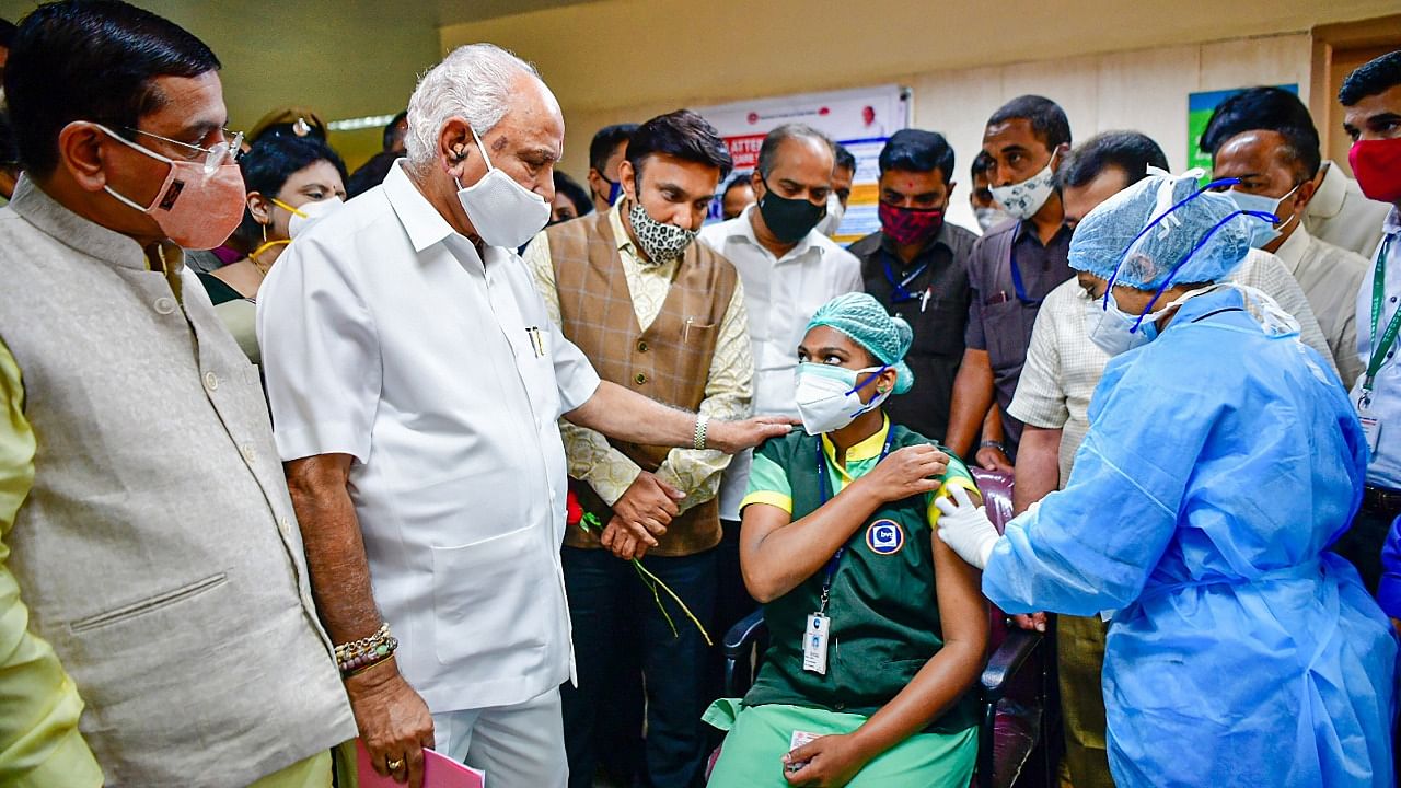 A medic administers the first dose of Covishield vaccine to a health worker in the presence of Karnataka CM B S Yediyurappa. Credit: PTI Photo
