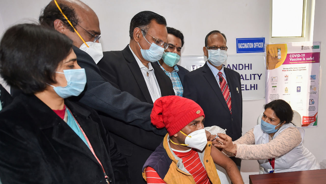 A medic administers the first dose of Covishield vaccine to a frontline worker in the presence of Health Minister Satyendar Kumar Jain, after the virtual launch of COVID-19 vaccination drive by Prime Minister Narendra Modi, at Rajiv Gandhi Super Speciality Hospital in New Delhi, Saturday, Jan. 16, 2021. Credit: PTI Photo