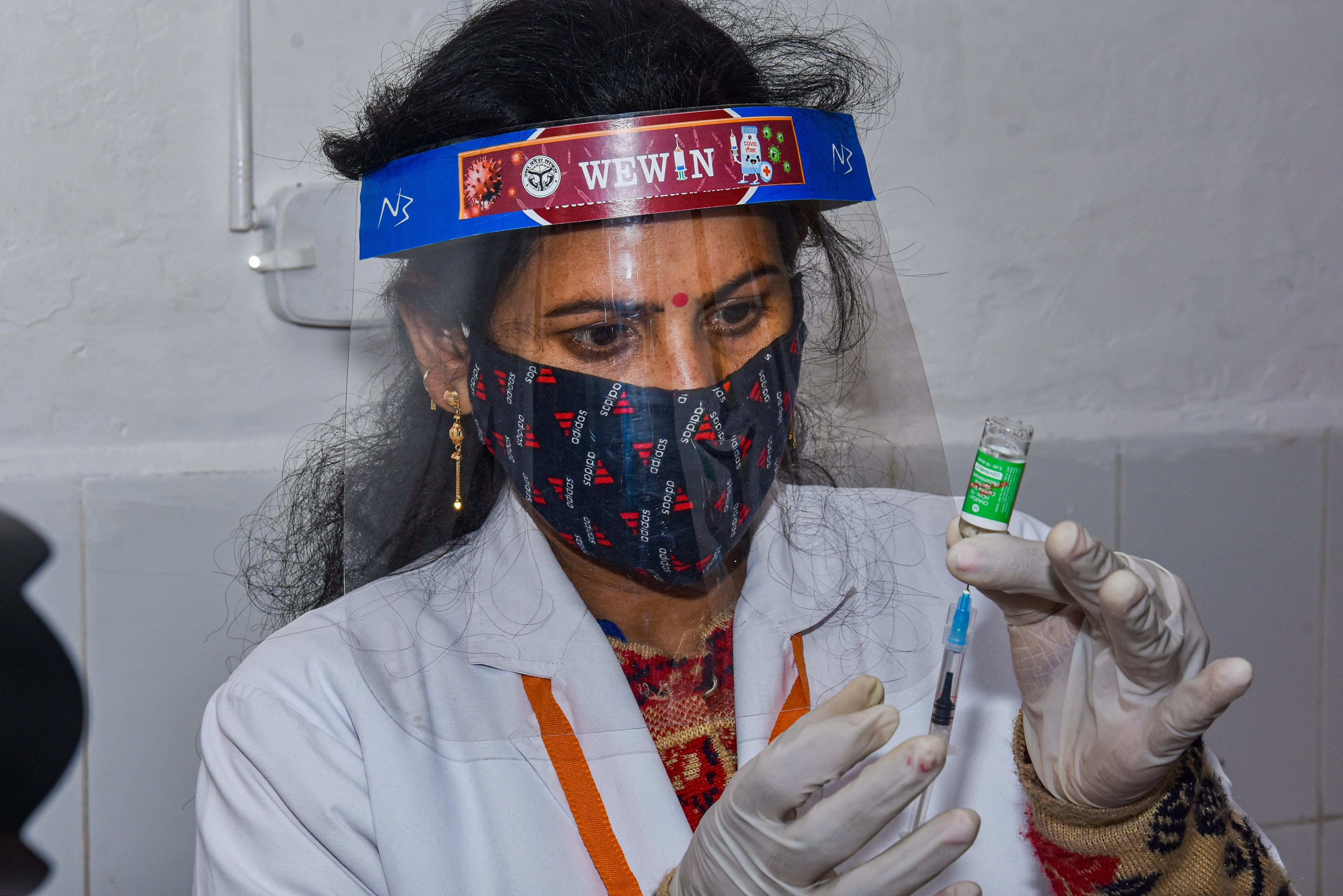 A nurse fills Covishield dose in an injection before administering to a frontline worker, after the virtual launch of COVID-19 vaccination drive by Prime Minister Narendra Modi, at Balrampur Hospital in Lucknow, Saturday, Jan. 16, 2021. Credit: PTI Photo