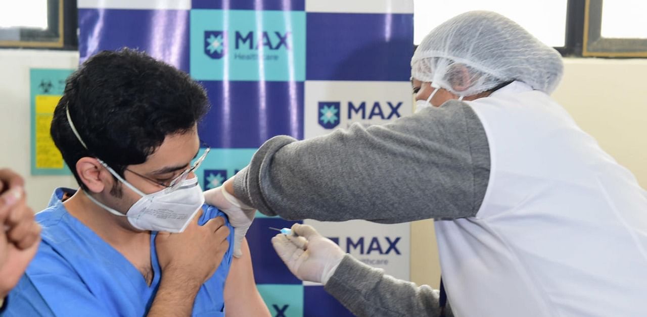 A nurse administers the Covid-19 vaccine to a frontline worker, after the virtual launch of COVID-19 vaccination drive by Prime Minister Narendra Modi, at Max Hospital in New Delhi, Saturday, Jan. 16, 2021. Credit: PTI Photo