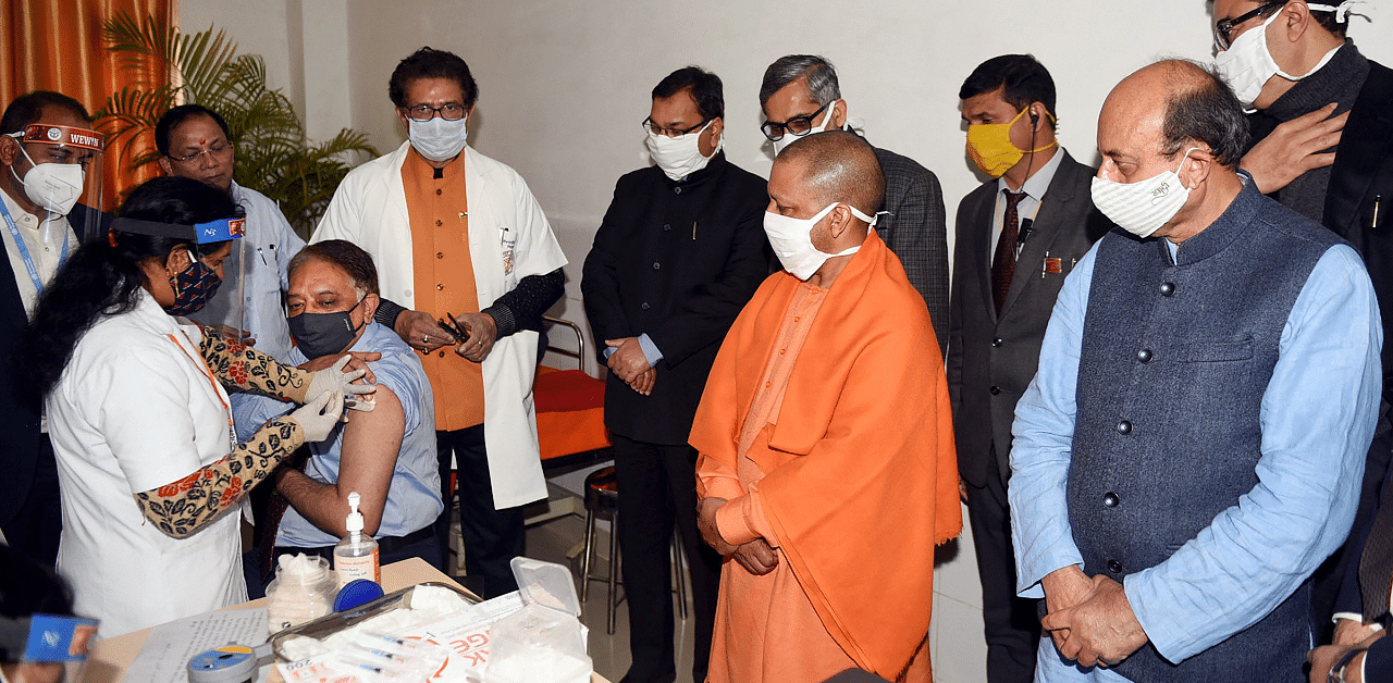 A medic administers the first dose of Covid-19 vaccine to a beneficiary in the presence of Uttar Pradesh Chief Minister Yogi Adityanath. Credit: PTI Photo