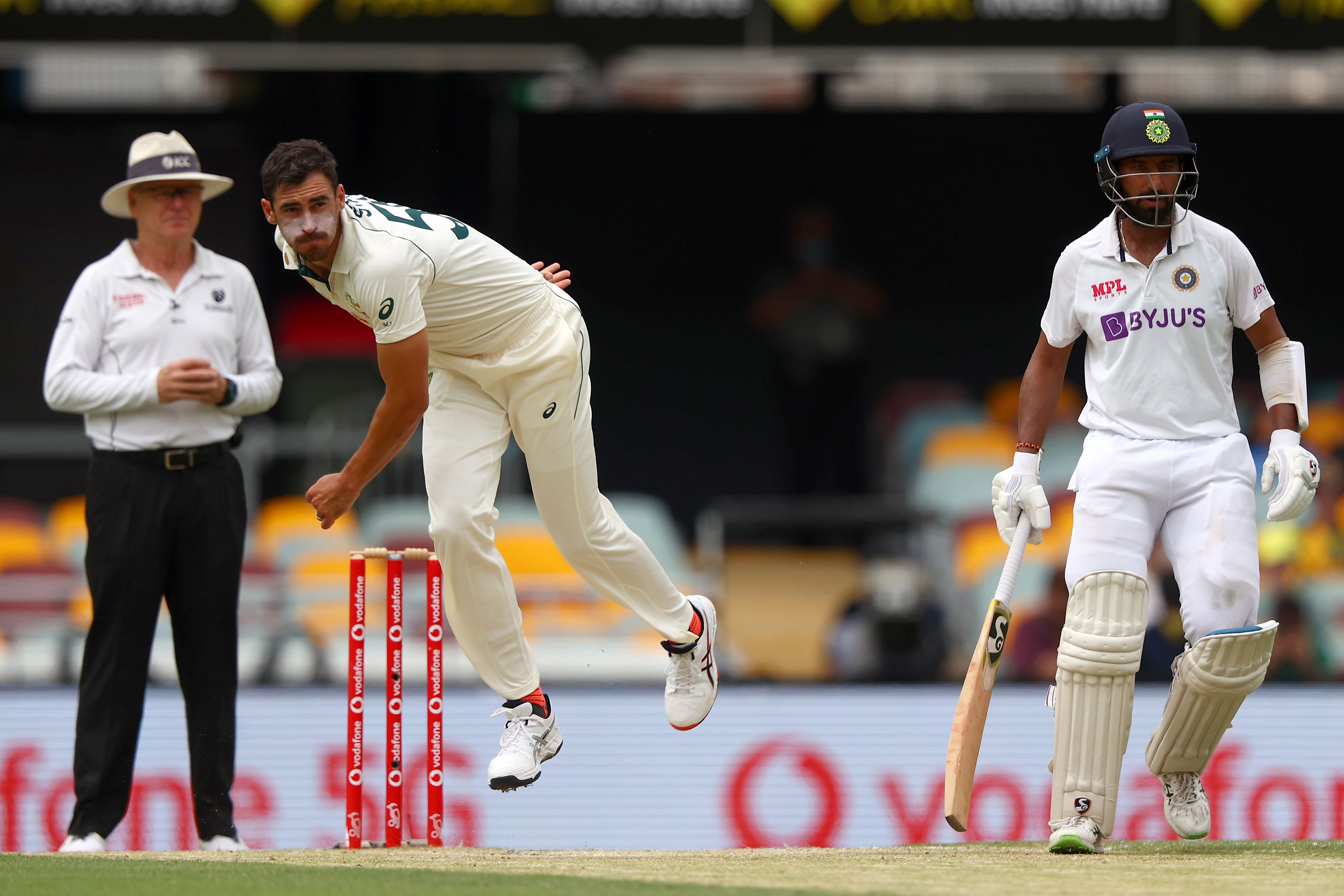 Australia's paceman Mitchell Starc (C) bowls as India's batsman Cheteshwar Pujara (R) looks on during the day three of the fourth cricket Test match between Australia and India at the Gabba in Brisbane. Credit: AFP