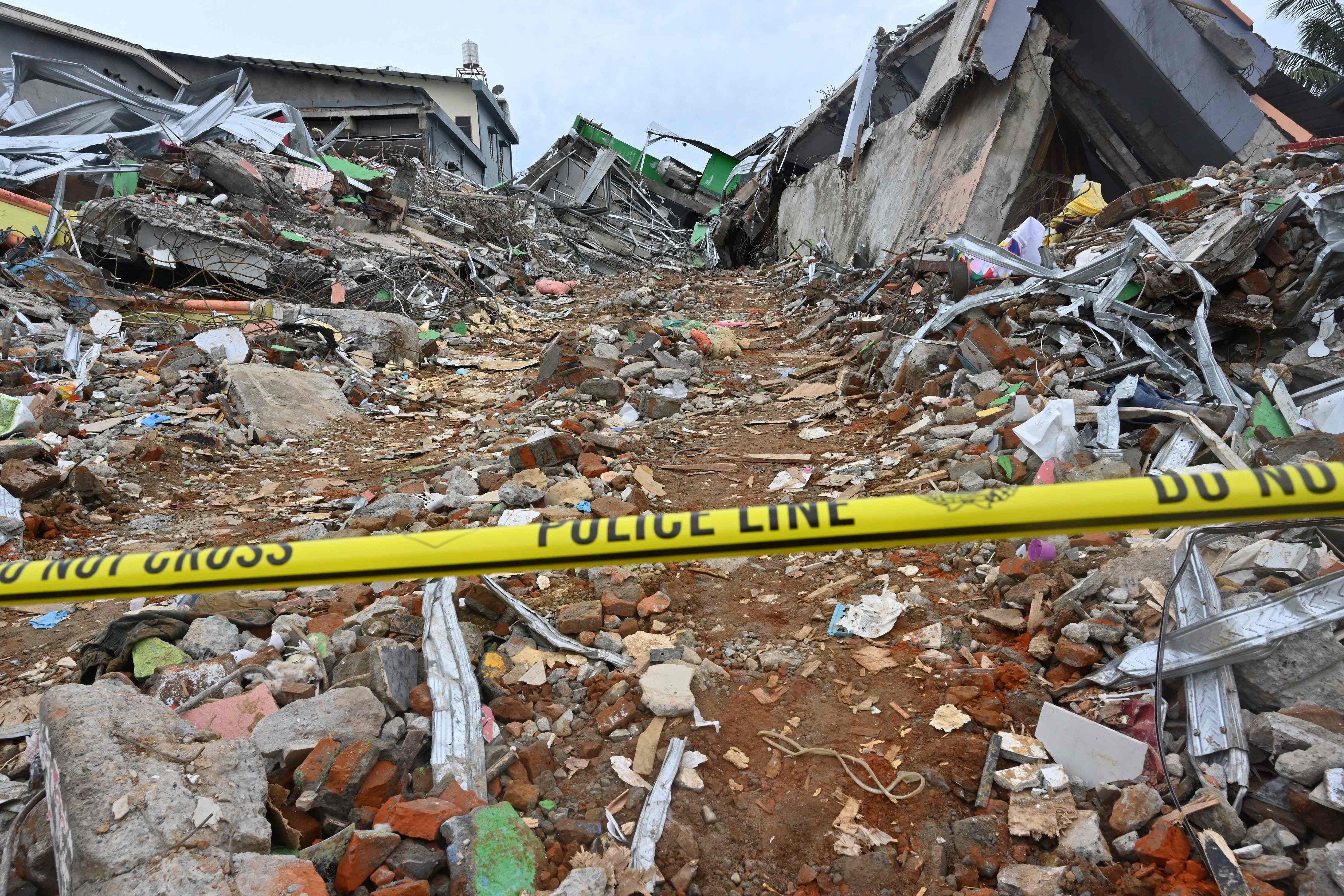 A police line is placed at a damaged building following a 6.2 magnitude earthquake in Mamuju. Credit: AFP Photo