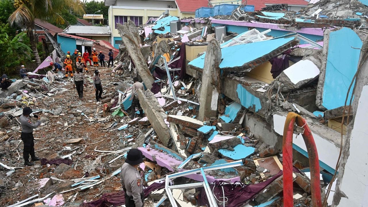 Police from a K-9 unit search for anyone trapped under the rubble at Mitra Manakarra hospital in Mamuju on January 17, 2021, which was badly damaged in the 6.2 magnitude earthquake on January 15. Credit: AFP Photo