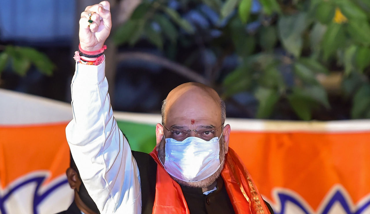 Union Home Minister Amit Shah waves at his supporters during an event, outside HAL airport in Bengaluru, Saturday, Jan. 16, 2021. Credit: PTI Photo