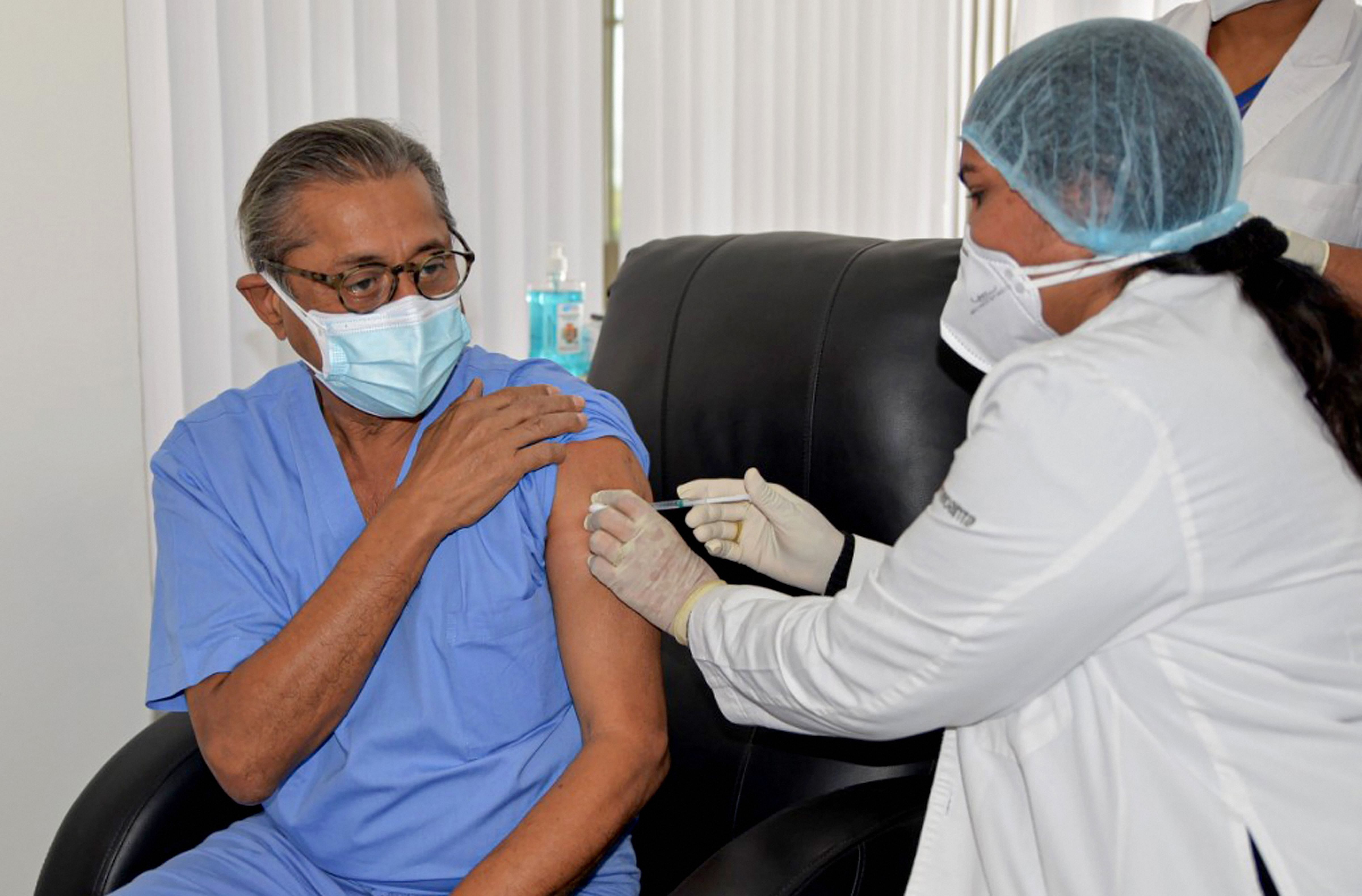 A medic administers the first dose of Covishield vaccine to Medanta Hospital Chairman & Managing Director Dr Naresh Trehan, after the virtual launch of COVID-19 vaccination drive by Prime Minister Narendra Modi, at Medanta Hospital in Gurugram, Saturday, Jan. 16, 2021. Credit: PTI Photo