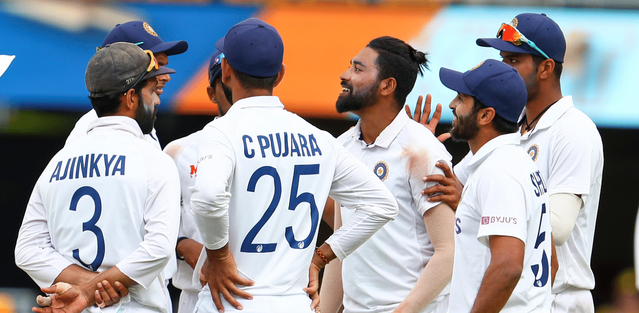 Mohammed Siraj (centre) is congratulated by teammates after dismissing Australia's Mitchell Starc during the fourth Test at the Gabba, Brisbane. Credit: AP Photo