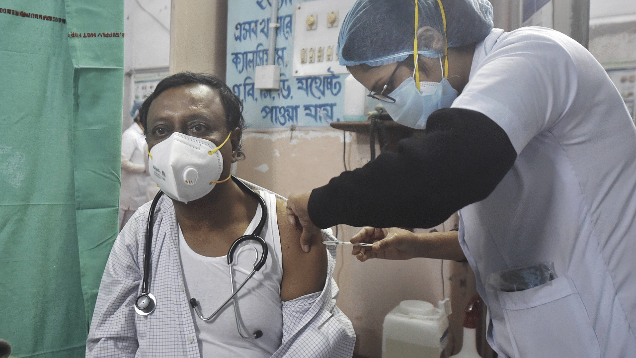 A medic inoculates the first dose of Covishield vaccine to Dr. Ashok Kr. Kundu of Howrah district Hospital, during a countrywide Covid-19 vaccination drive, in Howrah district, West Bengal. Credit: PTI Photo